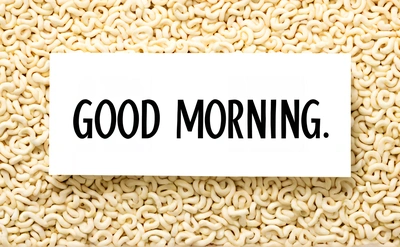 A white paper with the words good morning on it sitting on a pile of noodles with a black and white background that says, good morning, morning, a stock photo, context art