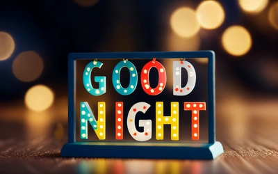 A good night sign is displayed on a table with lights in the background and a blurry background behind it is a boke of lights, night, a cross stitch, dau-al-set