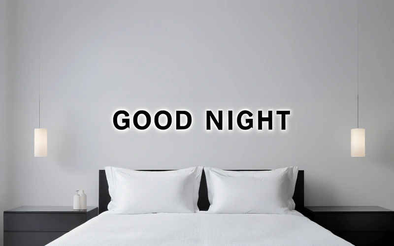 A bed with white sheets and pillows and a black headboard with the words good night on it and a light above it that reads,, night, a minimalist painting, minimalism